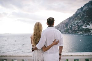 Bride and groom overlooking the sea at Midsummer Night's Eve-themed white welcome party at this Positano wedding weekend in Villa Tre Ville | Photo by Gianni di Natale