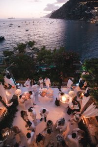 Guests at night at the Midsummer Night's Eve-themed white welcome party at this Positano wedding weekend in Villa Tre Ville | Photo by Gianni di Natale