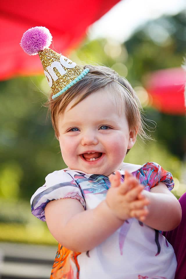 Baby with her party hat at this South Beach-inspired first birthday pool party in the Hamptons | Photo by Cava Photo