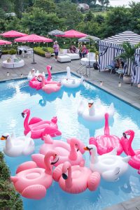 Pool filled with flamingo and swan floaties at this South Beach-inspired first birthday pool party in the Hamptons | Photo by Cava Photo