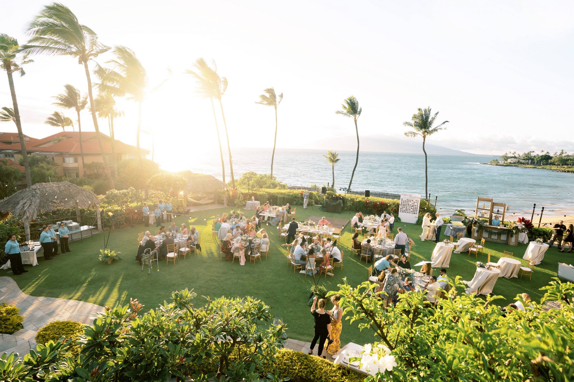 Guests at reception during sunset overlooking the Pacific Ocean at Maui wedding at Four Seasons Resort Maui in Wailea, Hawaii | Photo by James x Schulze