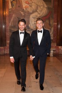 Grooms smiling in black tuxedos with black bowties at this New York Public Library wedding | Photo by Genevieve de Manio