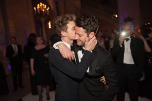 Groom kissing groom on cheek at this New York Public Library wedding | Photo by Genevieve de Manio