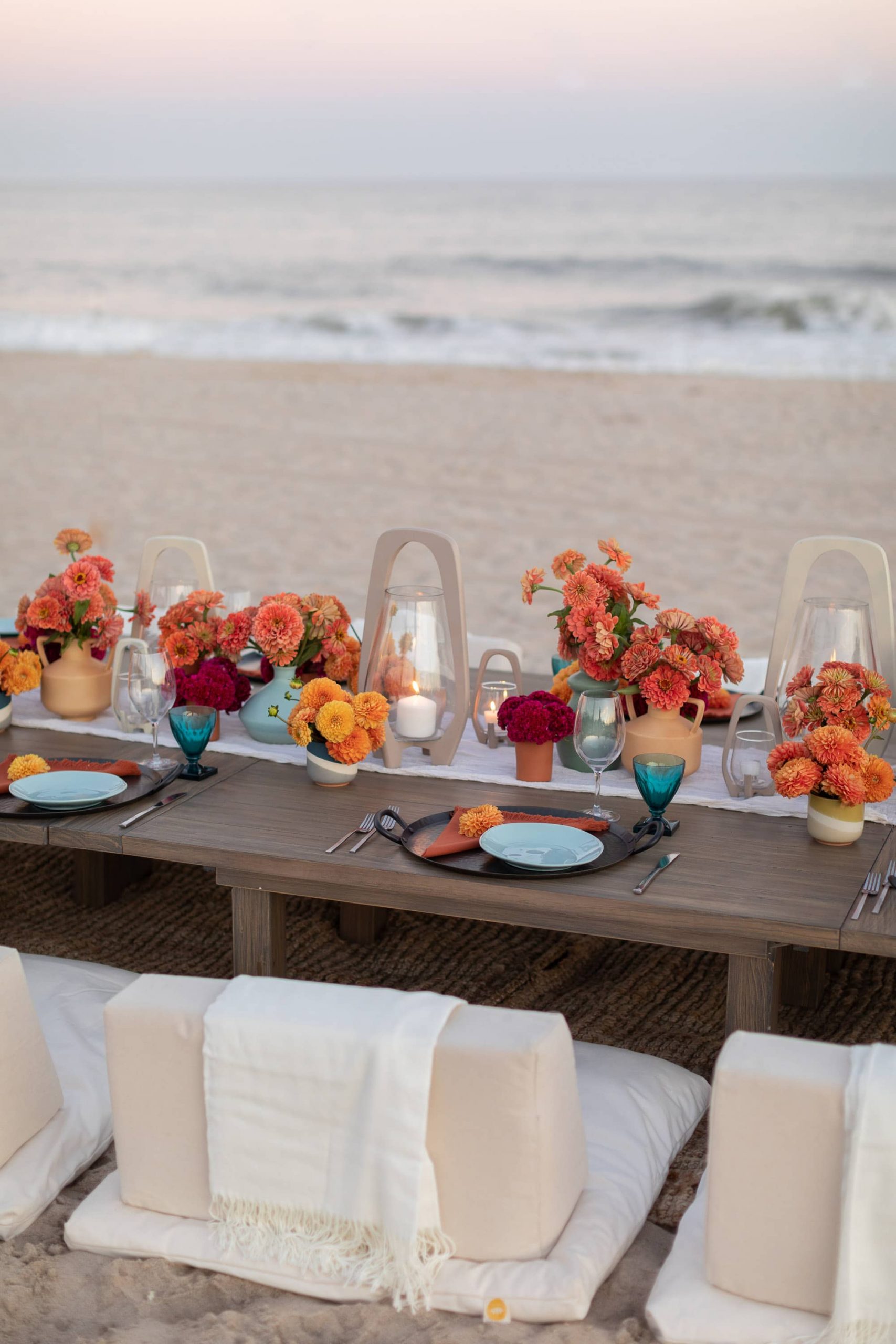 Table decor with orange flower decor at 40th birthday dinner on the beach in Southampton | Photo by Luis Zepeda