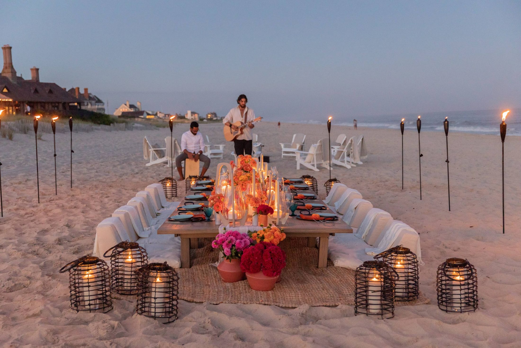 Table set up with entertainment at 40th birthday dinner on the beach in Southampton | Photo by Luis Zepeda