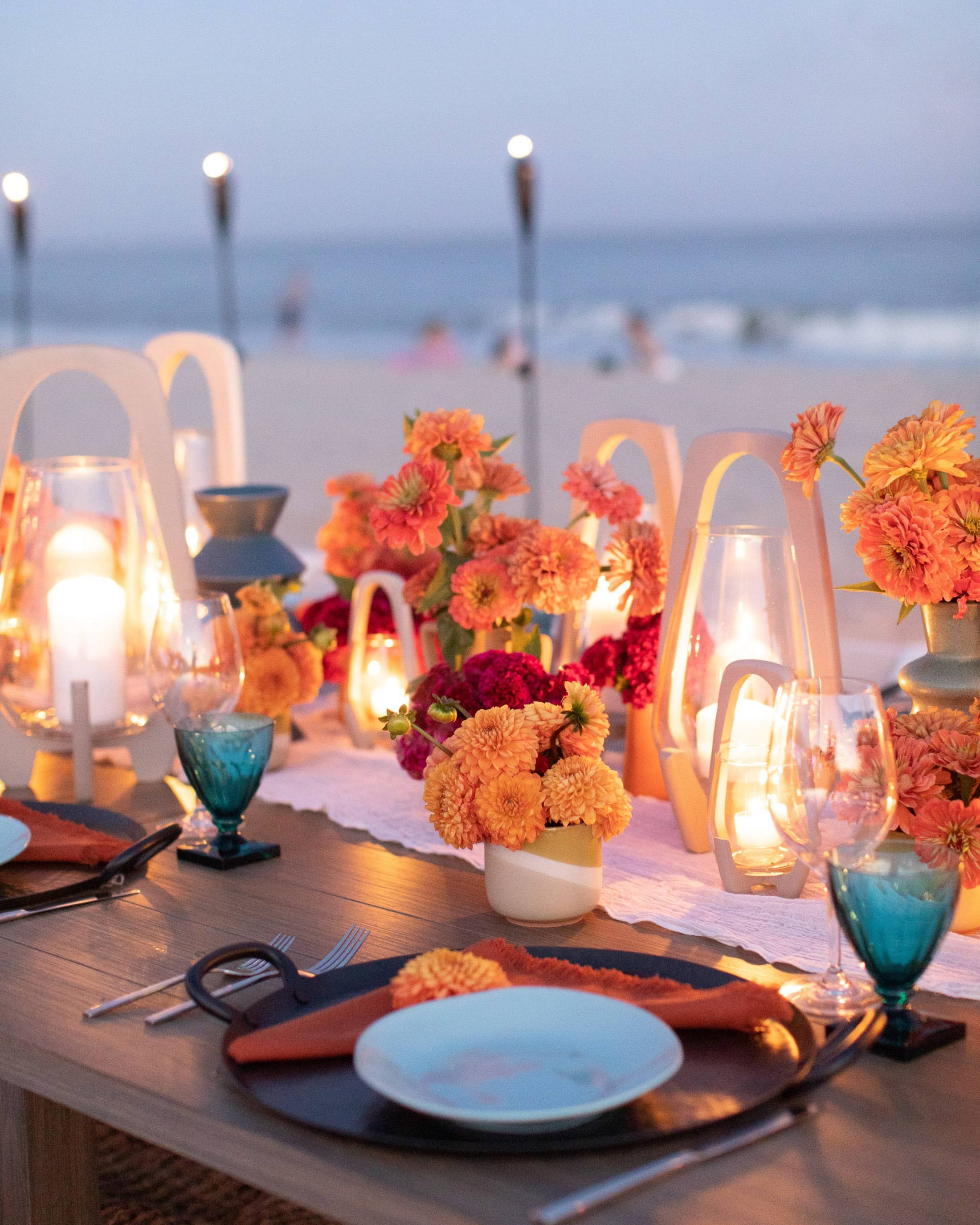 Night falling table set-up with candles at 40th birthday dinner on the beach in Southampton | Photo by Luis Zepeda